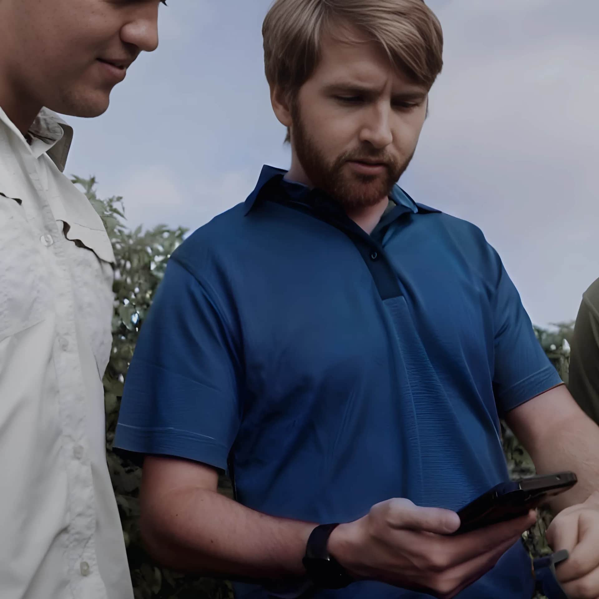 man looking at phone in field